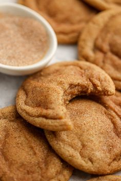 some cookies are next to a small bowl of sugar