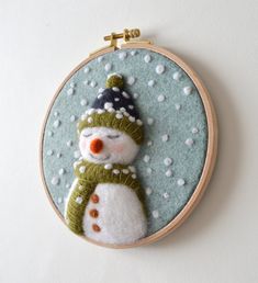 a snowman with a hat and scarf on it's head is embroidered into a hoop