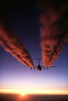 an airplane is flying in the sky at sunset