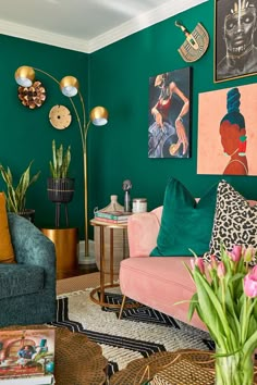 a living room with green walls and pictures on the wall, including a pink couch