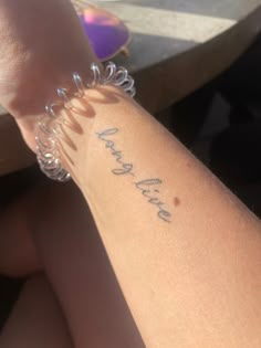 a woman's arm with the word love written on it in cursive writing