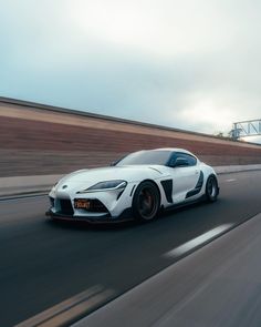 a white sports car driving down the road