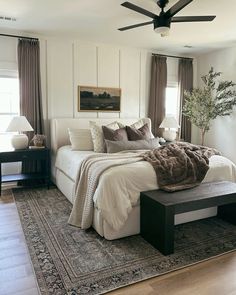 a bedroom with a large bed sitting on top of a rug next to a window