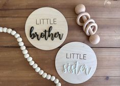 two wooden name plaques with bead necklaces and beads on a wood table top