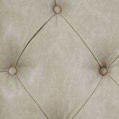 an upholstered white leather headboard with buttons