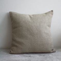 a beige pillow sitting on top of a white table