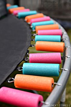 a row of different colored batteries attached to a metal rack with black mesh on top