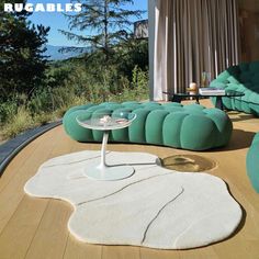 a living room filled with lots of furniture on top of a hard wood floor covered in white rugs