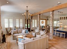 a living room filled with furniture and a fire place in the middle of a kitchen