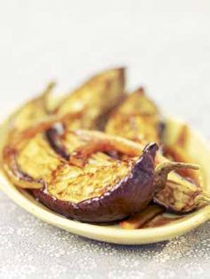 grilled eggplant and onions on a yellow plate with salted glaze