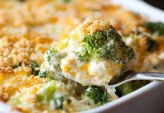 broccoli and cheese casserole in a white dish with a silver spoon