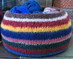 a multicolored knitted bean bag sitting on the ground