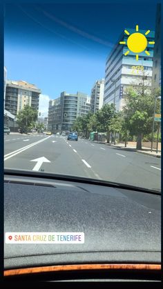 the view from inside a car looking at an empty street with buildings in the background