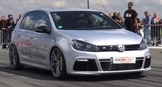 a silver car driving down a race track