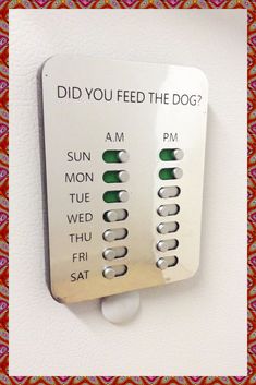 a white wall mounted to the side of a building with buttons on it that read, did you feed the dog?