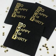 two black napkins with gold foil on them and some confetti scattered around