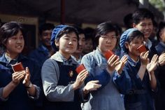 a group of people standing next to each other holding cell phones in front of them