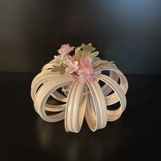 a vase filled with flowers sitting on top of a black table next to a wall