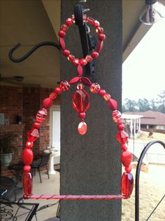 a red beaded necklace hanging from the side of a building next to a patio