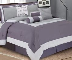 a bed with grey and white comforters in a room