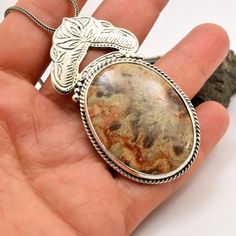 "Crazy lace agate necklace sterling silver large oval lace agate pendant orange brown beige antique bohemian style, artisan boho jewelry A beautiful large oval crazy lace agate stone with hues of brown, beige and orange in sterling silver statement pendant. Lovely autumn colors and winter colors too. The stone is set inside a bezel and framed with braided wire . On top of it there is an engraved antique floral pattern. I have oxidized it to bring out the details and achieved this bohemian look T Bohemian Silver Necklace With Large Stone, Brown Oval Natural Stone Necklace, Beige Bohemian Jewelry, Artisan Brown Necklace With Oval Pendant, Bohemian Jewelry With Oval Pendant Natural Stones, Artisan Brown Oval Jewelry, Bohemian Jewelry With Cabochon Oval Pendant, Antique Brown Agate Jewelry, Silver Oval Bohemian Necklaces