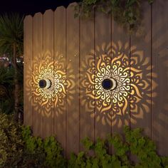 two decorative lights on the side of a wooden fence