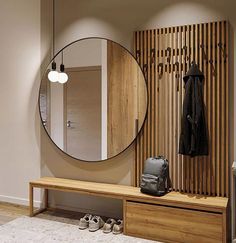 a coat rack, mirror and bench in a room with wooden slats on the wall