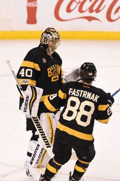 two hockey players standing next to each other on the ice