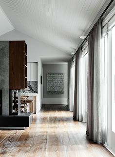 an empty living room with wood floors and white walls