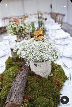 the table is set with white flowers and greenery, while a butterfly sits on top