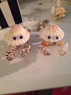 two seashells with googly eyes are sitting on a table