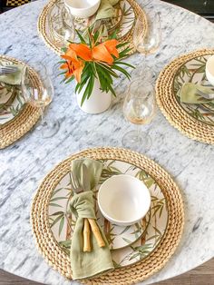 the table is set with place settings and flowers in vases on top of it