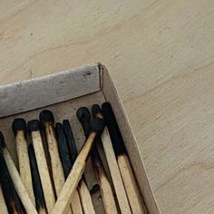 an open box filled with matches on top of a wooden table