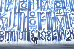 graffiti on the side of a building with letters and numbers painted in blue, black and white