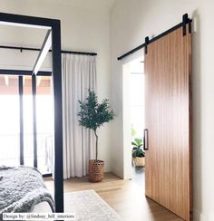 a bed sitting next to a wooden sliding door in a bedroom on top of a hard wood floor