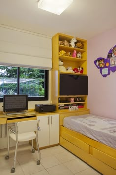 a bedroom with a bed, desk and computer on the wall next to a window