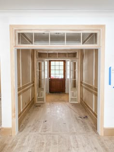 an empty room with wood paneling on the walls and wooden doors in the middle