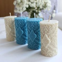 three blue and white candles sitting on top of a table