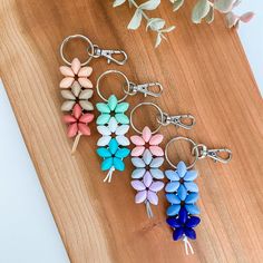 four flower shaped key chains on a wooden board