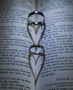 an open book with two wedding rings on it