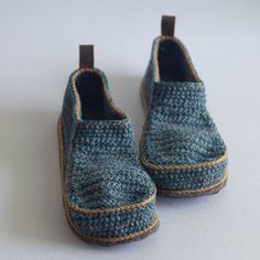 a pair of blue knitted shoes sitting on top of a white table