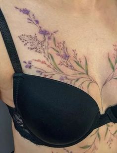 a close up of a woman's breast with flowers and leaves on her chest