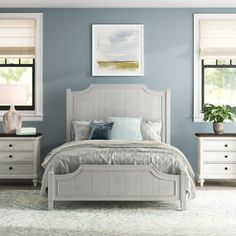 a bedroom with blue walls and white furniture