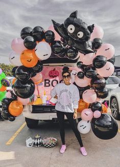 a woman standing in front of a truck with balloons