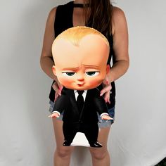 a woman is holding a fake baby doll