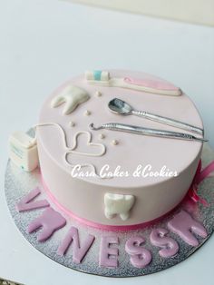 a cake decorated with pink icing and white fondant for a dentist's office