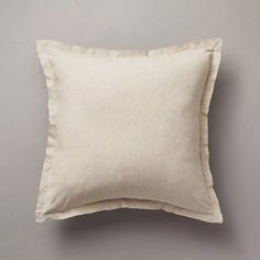 a white pillow sitting on top of a gray wall