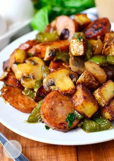 a white plate topped with potatoes and green peppers