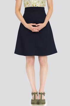 a woman in a short skirt is standing with her hands on her hips