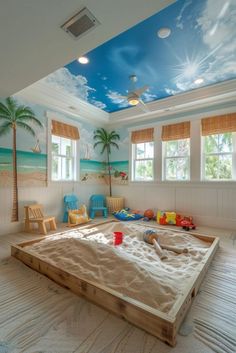 a room with a large sandbox on the floor and palm trees painted on the ceiling